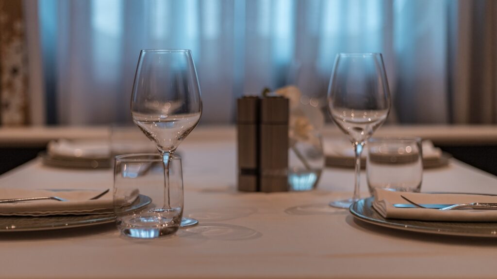 a table set for two with wine glasses and silverware