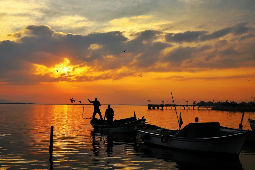 Silhouette of 2 Person Riding on Boat during Sunset