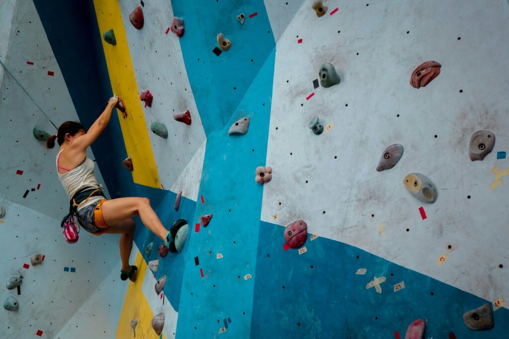 person in white tank top rock climbing - things to do on a cruise