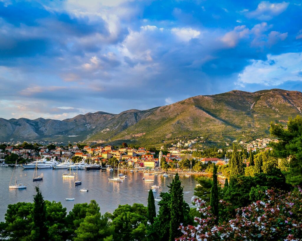 boats on body of water surrounded by trees and houses near mountain under blue and white sky at daytime - Croatia - Island hopping for couples